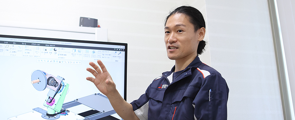 設計画面の前で解説する機械設計職の社員